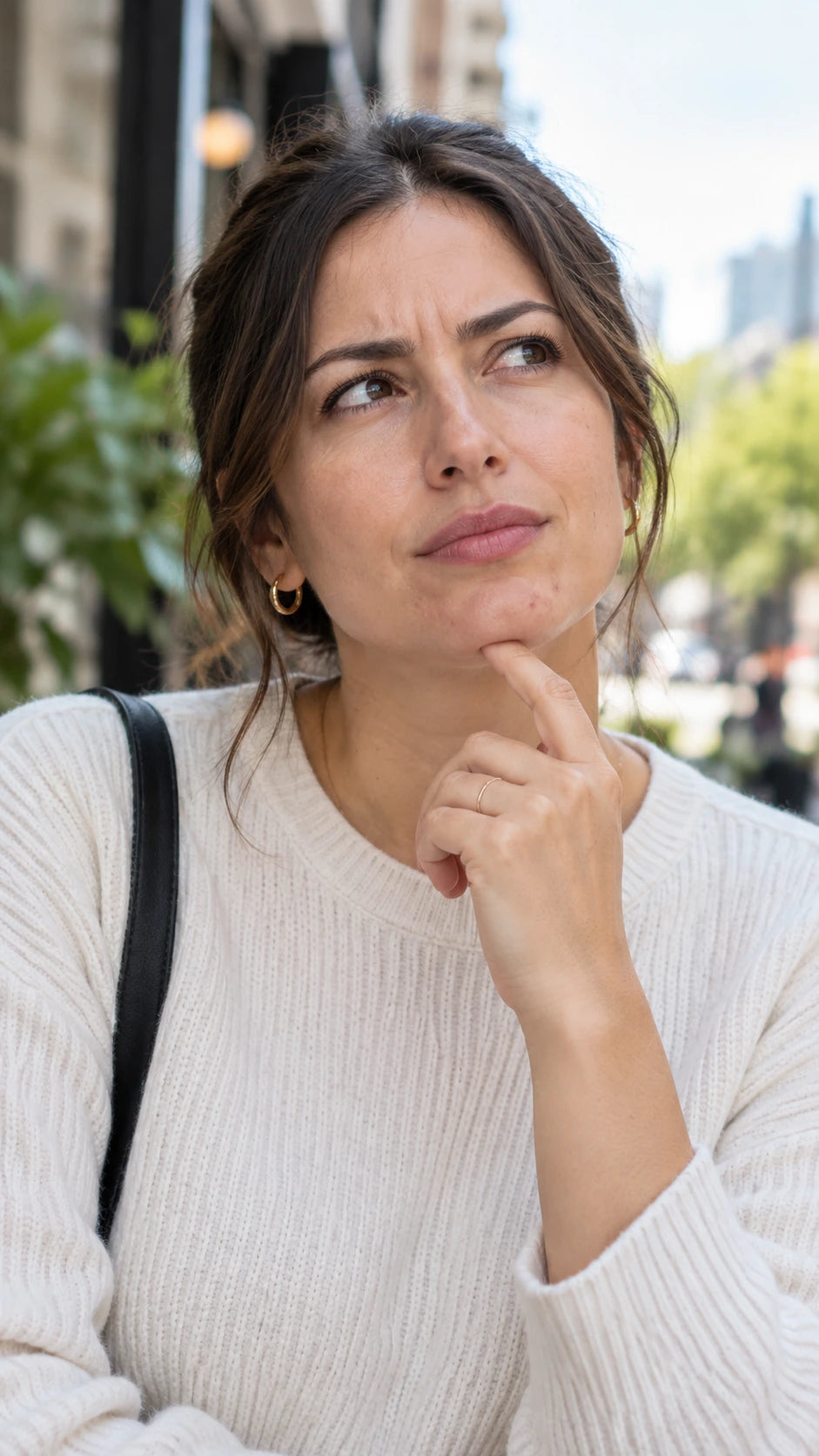 Portrait vertical d’une femme d’une trentaine d’années, pensive, avec quelques boutons visibles au menton