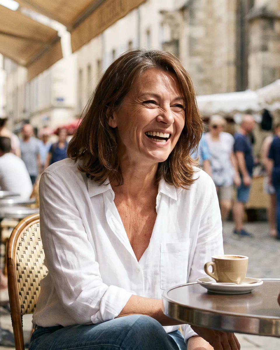 Femme mature souriante à la terrasse d’un café en ville